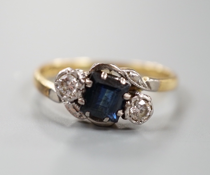 A 1960's 18ct gold, sapphire and diamond set three stone crossover ring, size M, gross weight 3 grams.